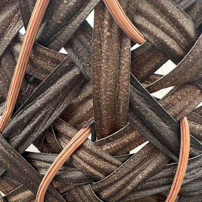 Closeup of cone basket with two thicker different brown bands making up most of the basket with lighter thinner brown bands interlocking 