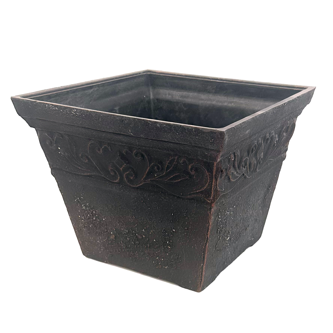 Square black pot brushed with copper with ornate pattern at top 