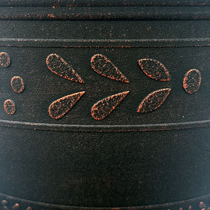 Close up of black pot with Brushed Copper band pattern that is an abstract flower and leaf pattern