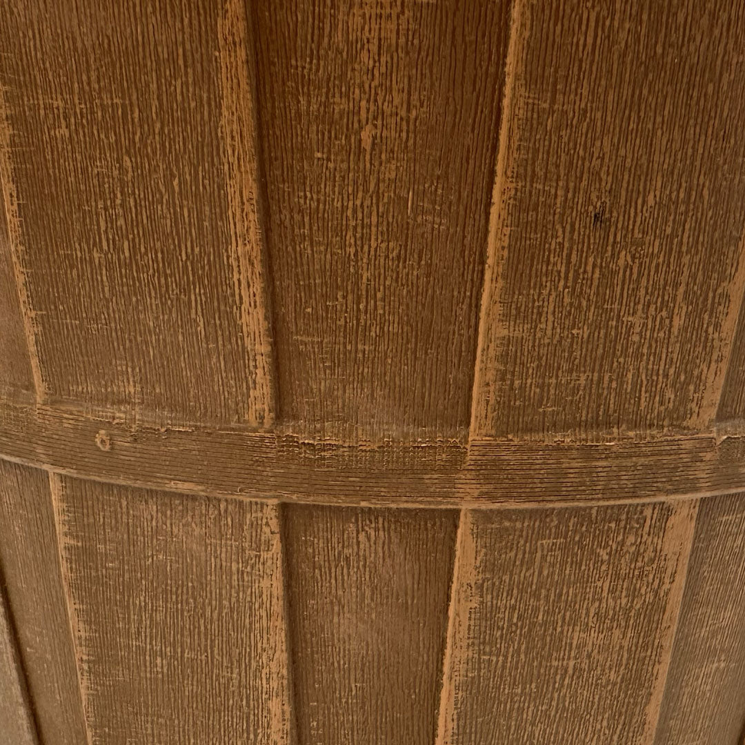 Closeup of brown bushel basket. Light brown paint is brushed on to give the pot dimension 